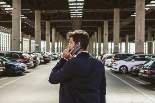 Man talking on a phone in a car park