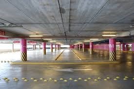 Interior of a parking garage with purple and yellow and black chevron columns and directional arrow